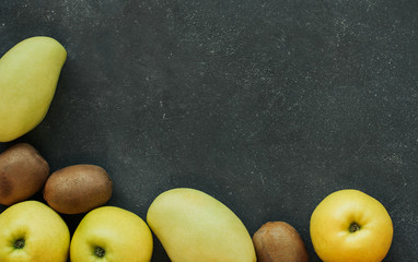  Green apples, mango and kiwi on a dark gray background. Mix of green fruits.