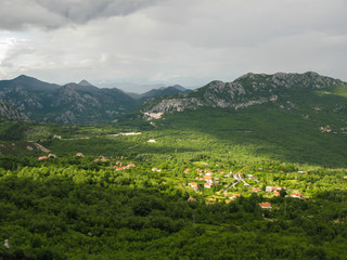 Fototapeta na wymiar panoramic view from the observation deck in the mountains to the Skadar lake and green valley, blue sky, white clouds, Montenegro