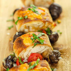 Baked pieces of tortilla wrap with chicken breast and Grana Padano cheese on the wood