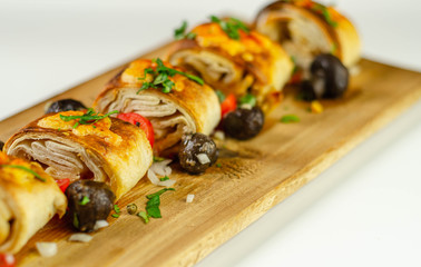 Baked pieces of tortilla wrap with chicken breast and Grana Padano cheese on the wood