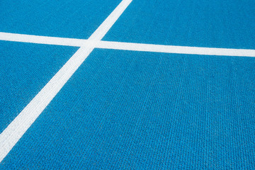 Fototapeta na wymiar Sport background. Blue running track with white lines in sport stadium. Top view