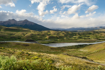 panoramica de lago y montañas con cielo nuboso 