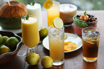 Obraz na płótnie Canvas Fresh Juice Mango, Juice Orange, Ice tea with blurred background.
