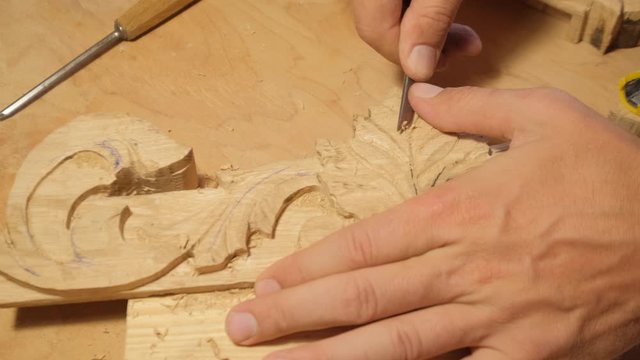 close up picture of woodcarver at work, handcrafting with wood	