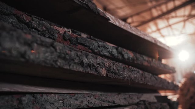 Close up of Fresh cutting Wooden Boards making from high old Trees. Brown Boards lie one on one in the Warehouse. Woods for making Furniture from. Slow motion video