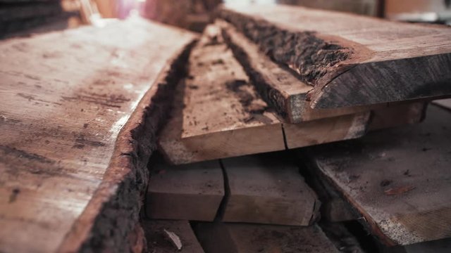 Few Old Wooden Boards Lie On The Table At The Workplace, Pieces Of Beautiful Woods. Future Furniture At The Warehouse Waiting For Work With It. Oak Boards At The Workshop