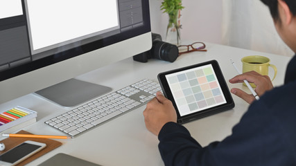 Young creative man giving concentrate on his tablet.