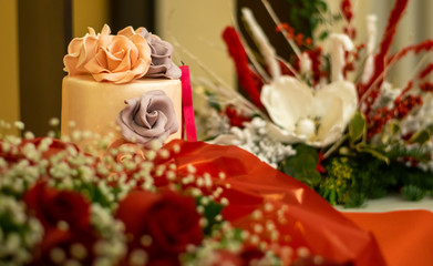 wedding cake with flowers bouquet of red roses on red valentine's day background
