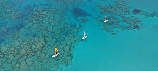 Aerial drone ultra wide photo of wind surfers practising in turquoise exotic paradise sandy bay