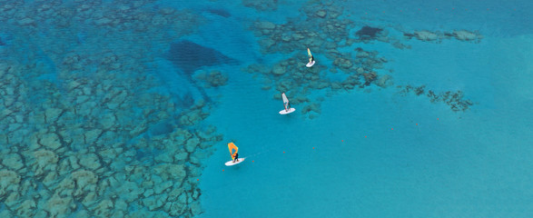 Fototapeta na wymiar Aerial drone ultra wide photo of wind surfers practising in turquoise exotic paradise sandy bay