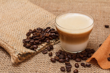 Coffee cappuccino and coffee beans on sackcloth background