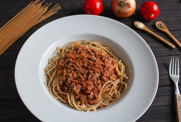 Spaghetti bolognese on dark wooden background. 