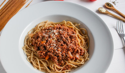 Spaghetti bolognese on white wooden background. 