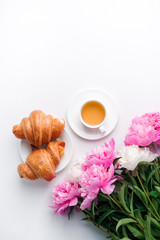 Breakfast for Valentines day with cup of tea, croissant, flowers on white table from above in flat lay style, seasonal springtime holiday background, blogger lifestyle
