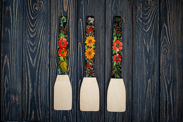 Ukrainian Petrykivka kitchen items, traditional decorative painting style, handicraft souvenirs on dark wooden background