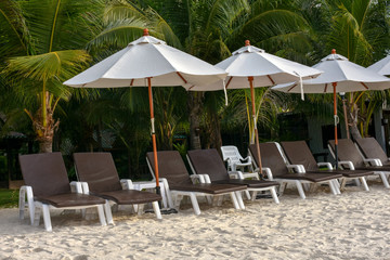 Easy armchairs and umbrellas on the white sand beach.
