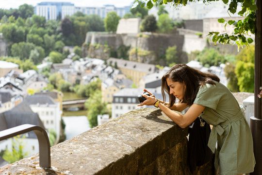 Young woman takes a picture on the Balcony of Europe in Luxembourg. Tourism and summer trip