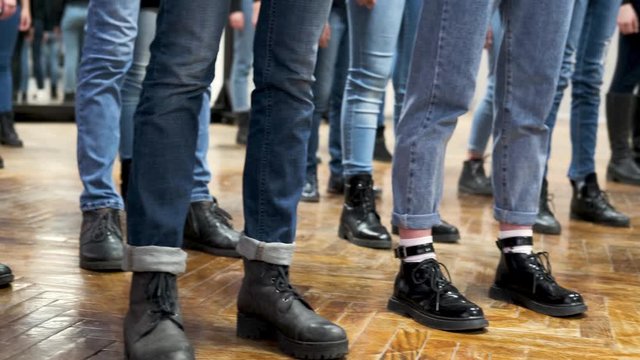 large group of childrens legs in blue jeans and black boots. training