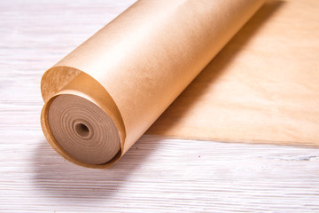 Roll of baking paper on wooden background
