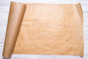 Roll of baking paper on wooden background