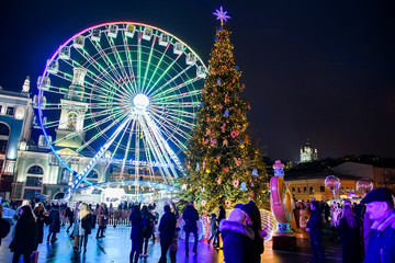 Christmas Tree, Ferris wheel and traditional Christmas fair on Kontraktova Square in Kyiv, Ukraine. December 2019