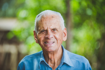 Portrait of smiling beautiful older male farmer. Elderly man at farm in summer day. Gardening activity. Brazilian elderly man. - obrazy, fototapety, plakaty