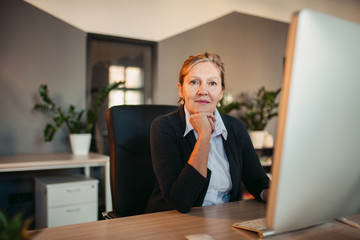 Portrait of a senior businesswoman on her workplace, looking at camera.