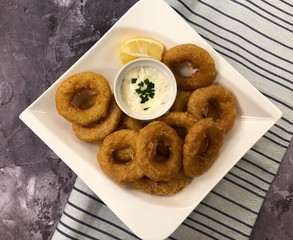 Deep fried Octopus rings with sauce Tartare. Italian food Calamari fritti.