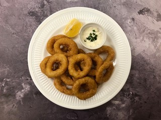 Deep fried Octopus rings with sauce Tartare. Italian food Calamari fritti.