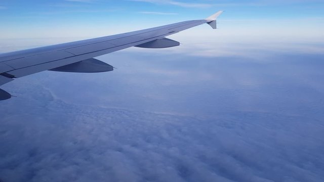Fliegender Ausblick aus Flugzeugfenster rechte Seite mit Fl&uuml;gel oberhalb geschlossener Wolken