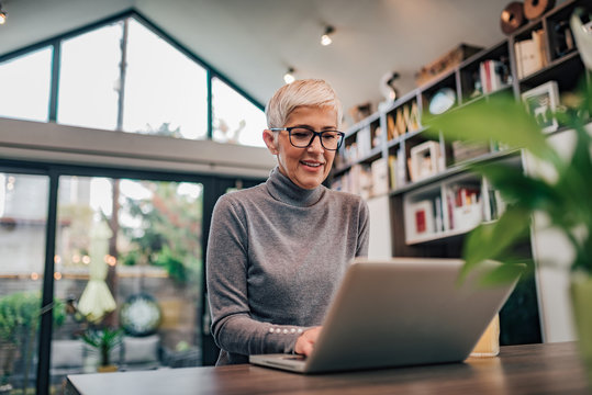 Portrait of a smiling senior woman using laptop.