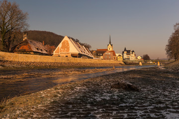 view of river and old town with church in winter
