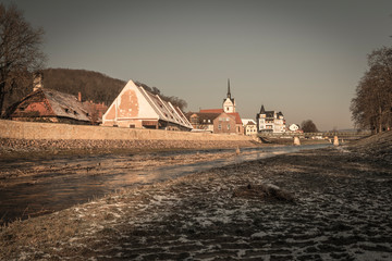 view of river and old town with church in winter