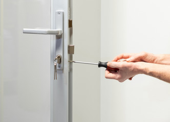glass Door knob repairing , worker Installs door knob, woodworker hands close-up - 312245579
