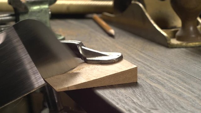 a carpenter saws a blank for a wooden comb with a Japanese saw