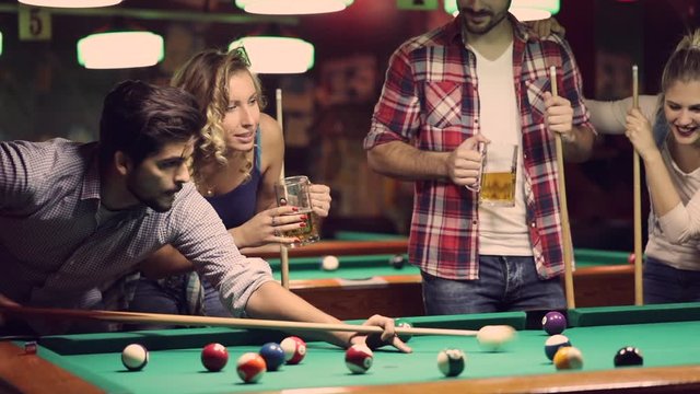 happy young people enjoying billiard game together