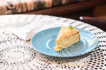 Napoleon cake on the table in a cozy chocolate bar. Tasty and not healthy food.
