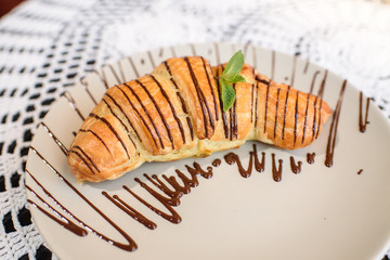 Chocolate croissant on the table in a cozy chocolate bar. Tasty and easy food.