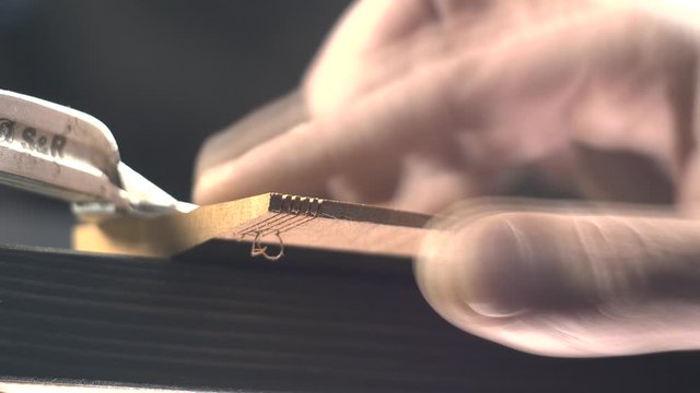 a carpenter saws a blank for a wooden comb with a Japanese saw