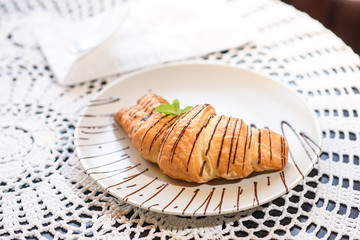 Chocolate croissant on the table in a cozy chocolate bar. Tasty and easy food.