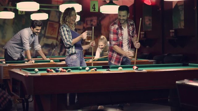 happy young people enjoying billiard game together