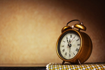 Golden vintage alarm clock showing five to twelve