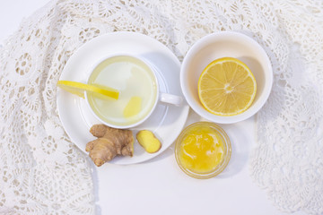 ginger tea with lemon and honey. Tea for immunity, a cold drink. ginger tea in a white cup on a white background. The concept of winter, health, immunity. A healthy detox drink. flat lay