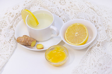 Fototapeta na wymiar ginger tea with lemon and honey. Tea for immunity, a cold drink. ginger tea in a white cup on a white background. The concept of winter, health, immunity. A healthy detox drink.