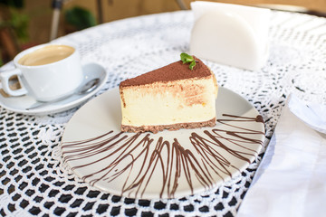 Coffee and Philadelphia cheesecake on a table in a cozy chocolate bar. Tasty and easy food.