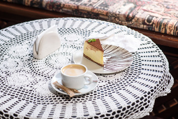 Coffee and Philadelphia cheesecake on a table in a cozy chocolate bar. Tasty and easy food.