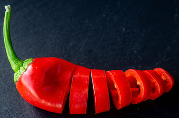 a red sliced ​​paprika on a slate plate