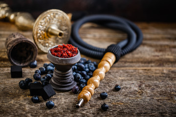 Stone hookah head on old rustic table with fruit flavoured tobacco - obrazy, fototapety, plakaty