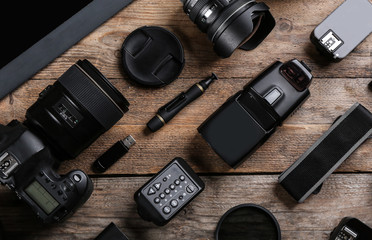 Flat lay composition with equipment for professional photographer on wooden table