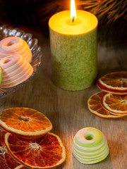 New year's tea. A fragrant green candle illuminates a red Cup of tea, a fir branch, and tangerines.